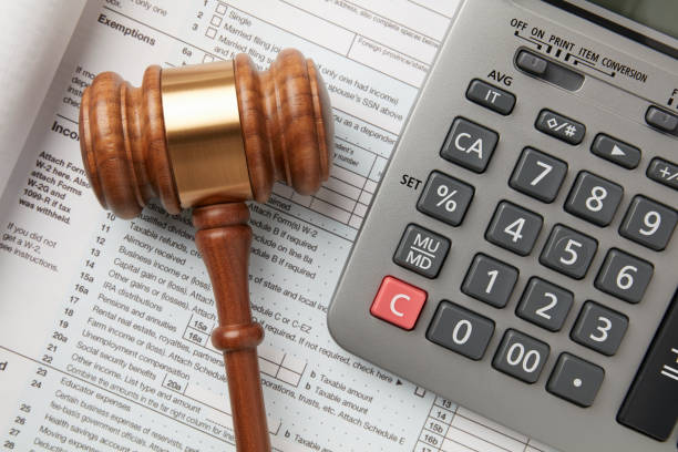 Tax return and calculator on white background with gavel